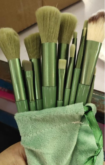 a person holding a bag of green makeup brushes